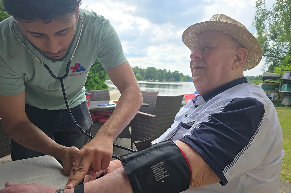 Pflegekraft misst den Blutdruck eines Senioren