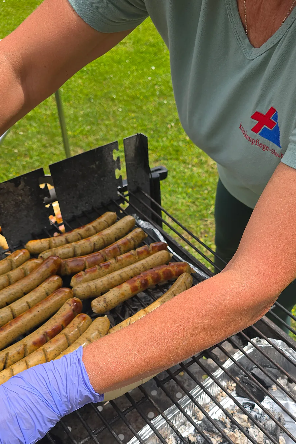 Teilnehmende genießen beim Sommerfest frisch Gegrilltes
